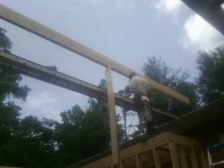 Carpenter setting a ridge beam over a new addition frame — Ice Dam Removal by Roofing Brothers in Davis Junction