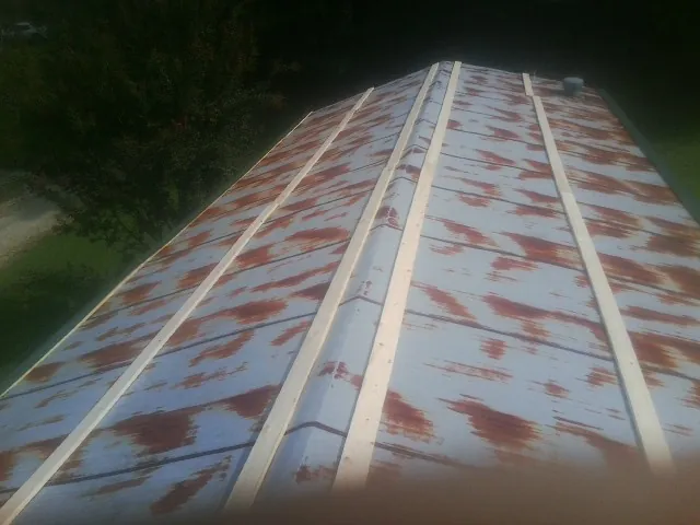 Rusted metal roof panels with new wood purlins before replacement — Storm Damage Roof Repair in Davis Junction by Roofing Brothers