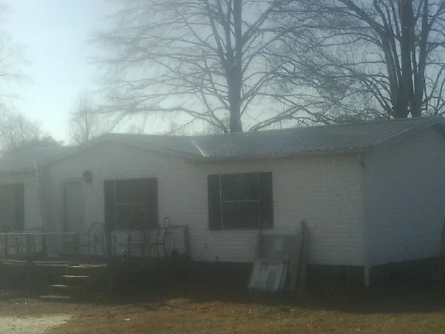 New metal roof on a white painted brick home on a foggy morning in Davis Junction